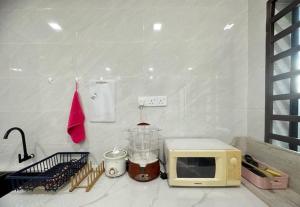 a microwave sitting on top of a kitchen counter at Ipoh stadium-18 pax (mahjong/5min to town) pets friendly in Ipoh +64 photos