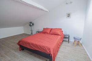 1 dormitorio con 1 cama con edredón rojo en Gite de labeylie - les dunes, en Saint-André-de-Seignanx