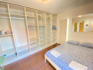 a bedroom with white shelves and a bed at Charming National Street Room in the Heart of Antwerp in Antwerp