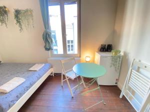 a small room with a bed and a table and a window at Charming National Street Room in the Heart of Antwerp in Antwerp
