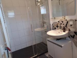 a bathroom with a sink and a shower at Ehemalige Bibliothek Apartment für 2 mit Küche Kamin Netflix Parken und Hofladen in Steinhöfel +46 photos
