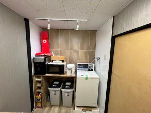 uma sala de escritório com frigorífico e lixo em Lucky Hotel em Tóquio