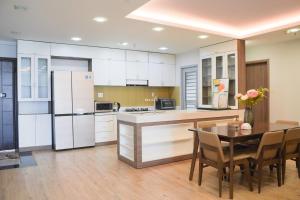 a kitchen with white appliances and a table with chairs at Apartment Scenic Valley Quận 7 in Ho Chi Minh City