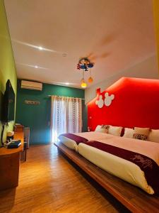 a bedroom with a large bed with a red headboard at 覓思旅Miss inn in Hengchun South Gate