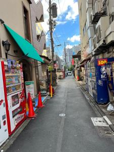 an empty street with orange cones in front of buildings at Lucky Hotel in Tokyo