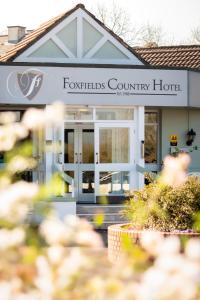 Foxfields Country Hotel في Langho: مبنى عليه لافته مكتوب عليها فندق ريفي النافورة