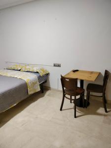 una camera con letto, tavolo e sedie di Piccadilly Centre Deluxe ad Alicante