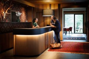 a man and a woman standing at a counter at Hotel Vioz in Peio Fonti