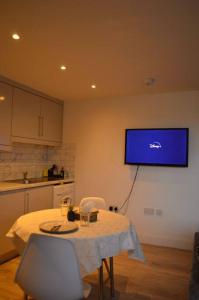 a kitchen with a table and a tv on the wall at The Bricklane Artistic Studio in London