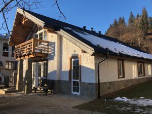 a house with a balcony on top of it at Cottage Familiya in Verkhovyna