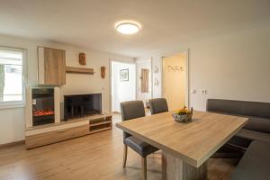 a living room with a dining room table and a fireplace at Usedomer Bungalows in Korswandt