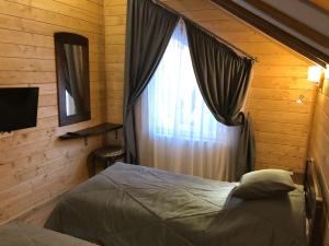 a bedroom with a bed and a window at Cottage Familiya in Verkhovyna