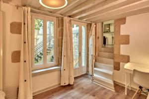 un pasillo con ventanas y escaleras en una casa en "La Revenderie", appartement calme sur cour privative, hyper centre de Nevers by PRMO C0NCIERGERIE, en Nevers