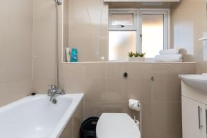 a white bathroom with a toilet and a sink at 19A Apartment- Stylish & Cozy 1BR in The Heart of Crawley in Crawley