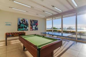 Habitación con 2 mesas de ping pong y ventanas en VISTAMAR COSTAHORIZONTE CONCON, en Concón