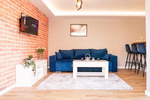 a living room with a blue couch and a brick wall at The Rugby Accommodation in Rugby