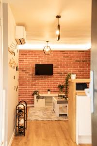 a living room with a brick wall and a tv at The Rugby Accommodation in Rugby