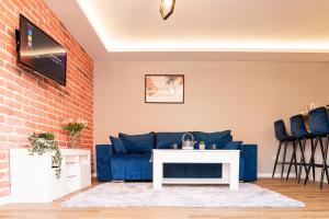 a living room with a blue couch and a brick wall at The Rugby Accommodation in Rugby