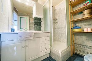 een witte badkamer met een wastafel en een douche bij L'ivresse des sommets #AH2 in Huez