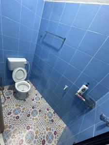 W wyłożonej niebieskimi kafelkami łazience znajduje się toaleta. w obiekcie WAJA Homestay w mieście Kampung Raja
