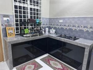 a kitchen with a counter top with a stove at WAJA Homestay in Kampung Raja