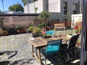 un patio con mesa de madera y sillas en Superbe appartement avec belle terrasse, en Bischheim