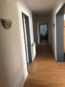 an empty hallway with white walls and wooden floors at "Spacious Family Apartment & Parking near Strasbourg Center with easy bus Access" in Bischheim