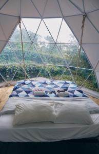 - un lit dans une tente en forme de dôme avec vue dans l'établissement Quinta do Abacate - Glamping Park, à Angra do Heroísmo