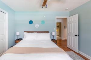 a bedroom with a large white bed with blue walls at Golden Isles Lrge Home- Huge Pool, Hot Tub, Game Rm in Brunswick