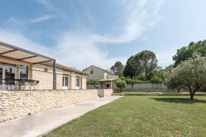 a house with a stone wall and a yard at Villa en Provence in Bollène