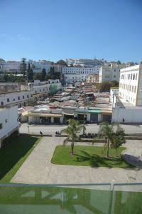 a city with a lot of buildings and palm trees at RIAD TANJA by chef Moha in Tangier