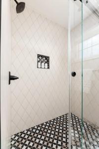 a shower with a glass door in a bathroom at Midtown Modern - urban condo walkable to bars and beach in Traverse City