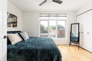 a bedroom with a bed and a large window at Midtown Modern - urban condo walkable to bars and beach in Traverse City