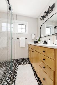 a bathroom with a shower and a sink and a mirror at Midtown Modern - urban condo walkable to bars and beach in Traverse City