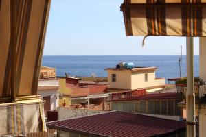a view of roofs of buildings and the ocean at La Maison Dorée in Giardini Naxos