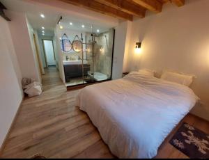 una camera con un letto bianco e un grande specchio di Rêve de neige a Font-Romeu-Odeillo-Via