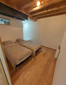 2 letti in una camera con pavimenti in legno di Rêve de neige a Font-Romeu-Odeillo-Via