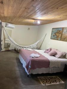 a bedroom with a bed with a hammock in it at Safira Beach House in Pipa