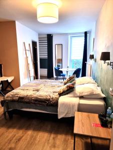 a bedroom with a bed and a desk and a table at Le 9 en Cuisine in Rabastens