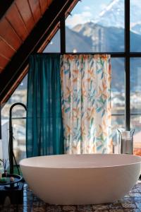 a large white bath tub in front of a window at Cottage Veranda in Kazbegi