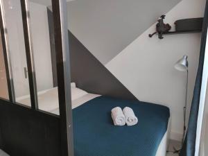 2 toallas en una cama en una habitación pequeña en L'atelier Clissonnais, plein centre historique, en Clisson