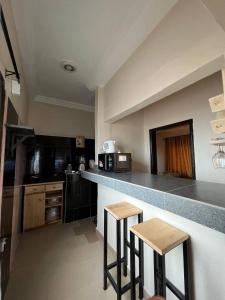 a kitchen with two bar stools and a counter top at MonGite in Cotonou