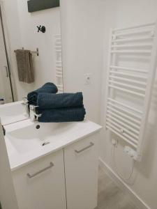 a bathroom with a sink and a mirror and towels at L'atelier Clissonnais, plein centre historique in Clisson