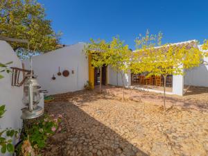 una casa blanca con árboles delante de ella en Cubo's Cortijo El Perezon en Archidona