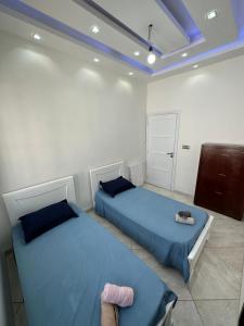 twee bedden in een kamer met blauwe lakens bij maison luxe et conviviale à HYDRA F6 in Alger