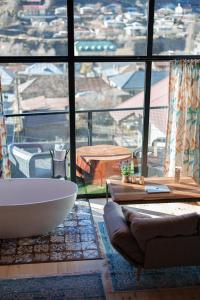 a bathroom with a tub and a large window at Cottage Veranda in Kazbegi