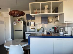 a kitchen with white cabinets and a blue counter top at Playa Blanca in La Serena