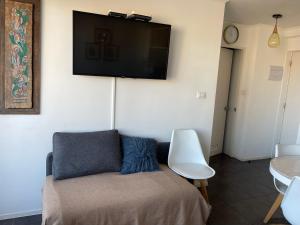 a living room with a couch and a tv on the wall at Playa Blanca in La Serena