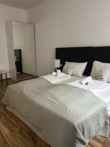 a large bed with white sheets and a gray blanket at Cozy City Center Apartments in Vienna