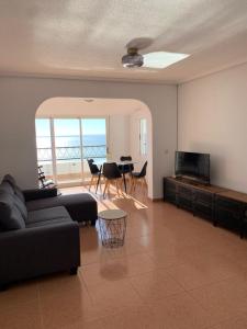 ein Wohnzimmer mit einem Sofa und einem Tisch mit Stühlen in der Unterkunft Como en Casa 2 in Santa Pola